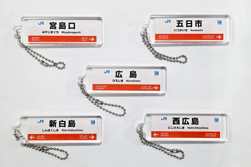 JRの駅名標を模したアクリルキーホルダーが5つ並んでいます。宮島口、五日市、広島、新白島、西広島など、広島県内のJR駅名がデザインされています。