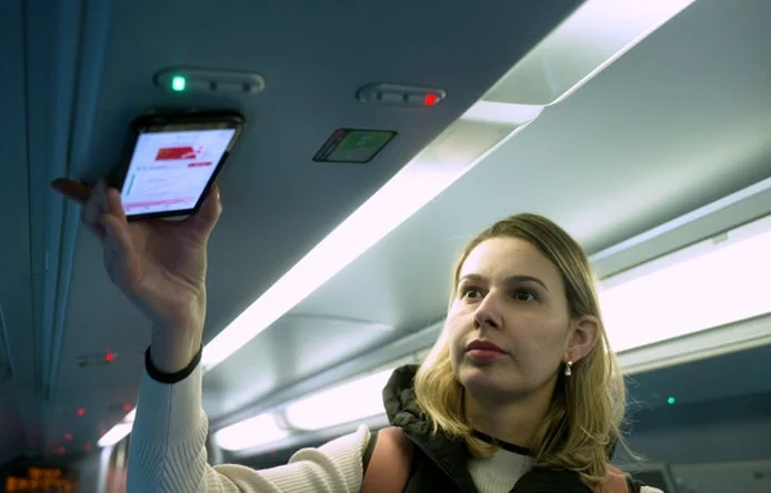 座席上部の読み取り部にタッチする様子