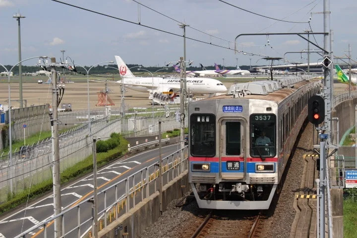 空港を背景に走行中の芝鉄3500形
