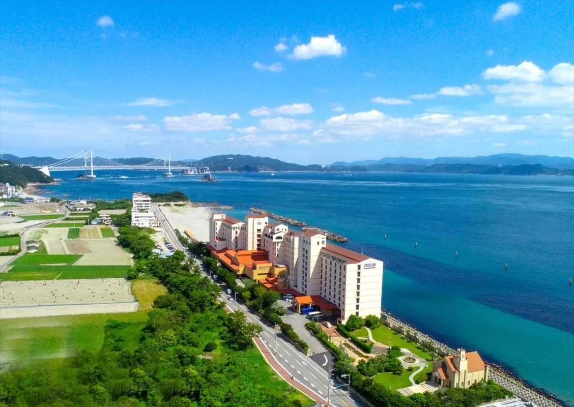 晴れた日に海沿いのリゾートホテルを上空から捉えた写真
