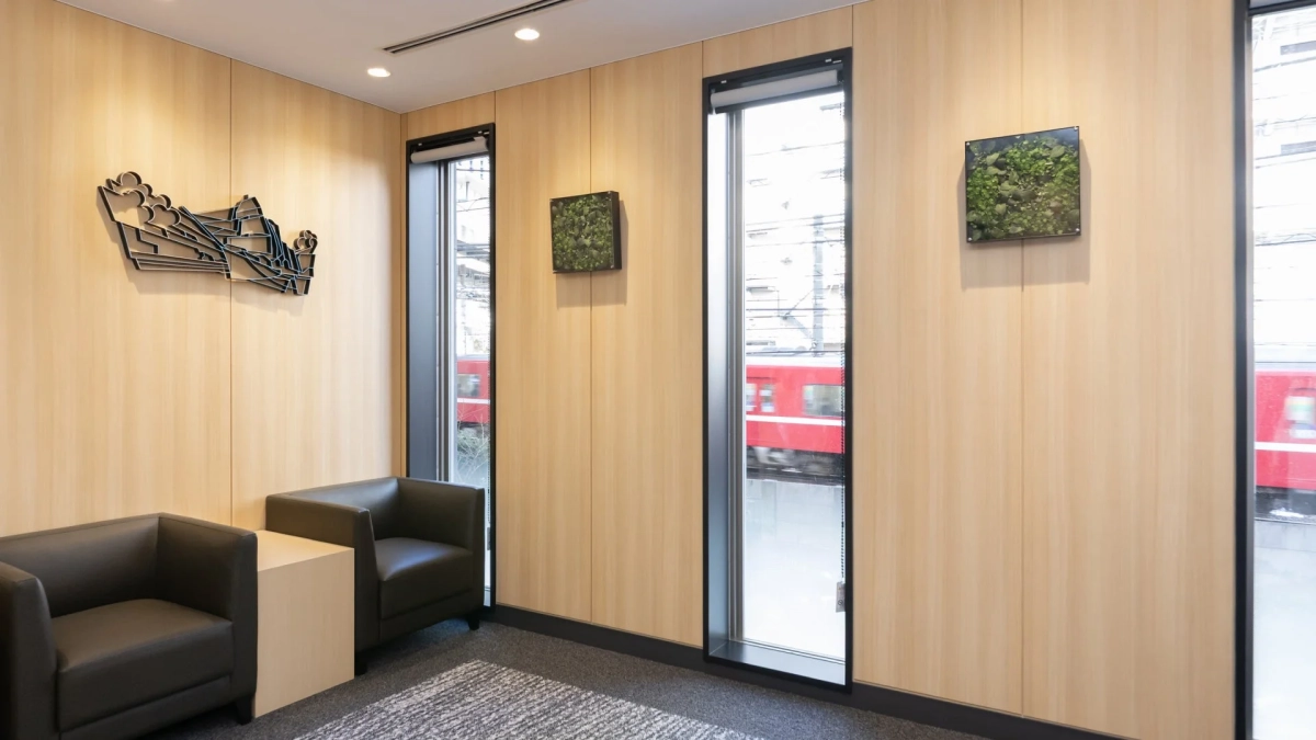 木目調の壁と窓から電車が見えるモダンな室内空間