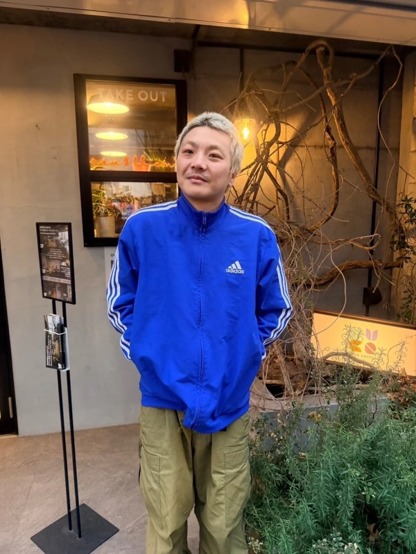 アディダスのトラックジャケットを着た男性