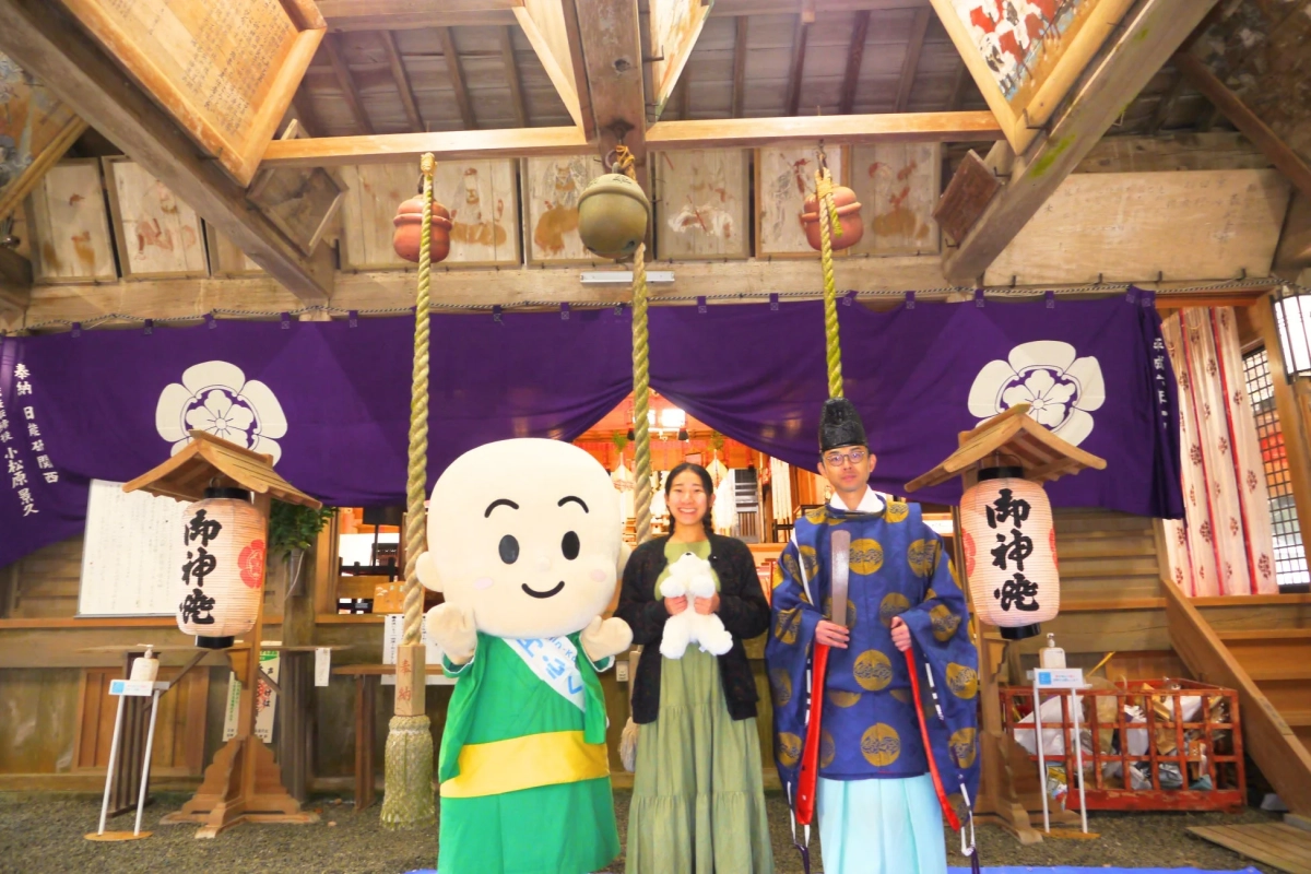 ぬいぐるみを抱えた参拝者と円心くん