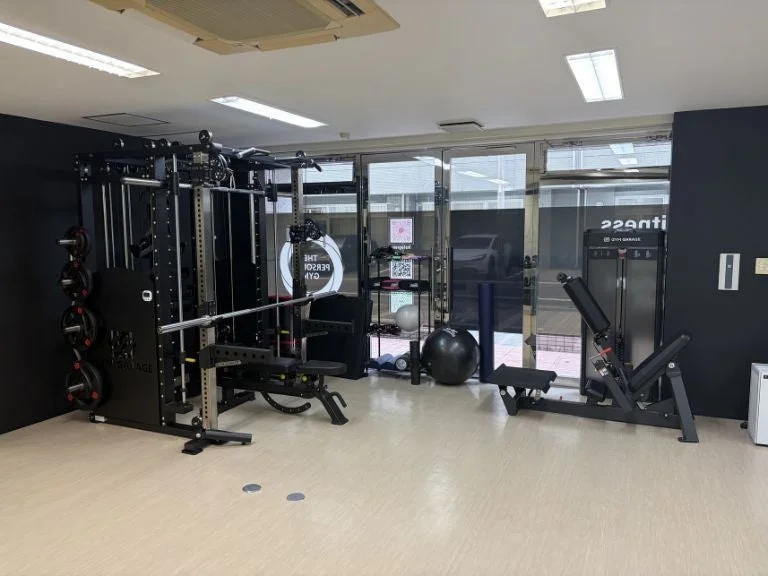 様々なトレーニング器具が設置された、清潔感のあるモダンなジムの室内風景