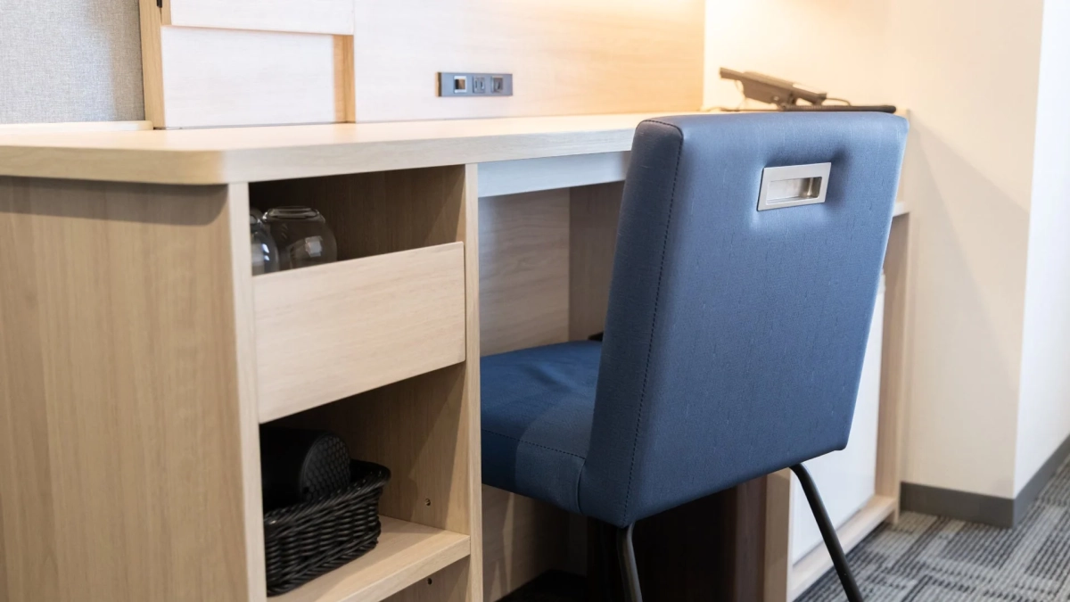 木目調のデスクと鮮やかな青い椅子が配置されたワークスペース