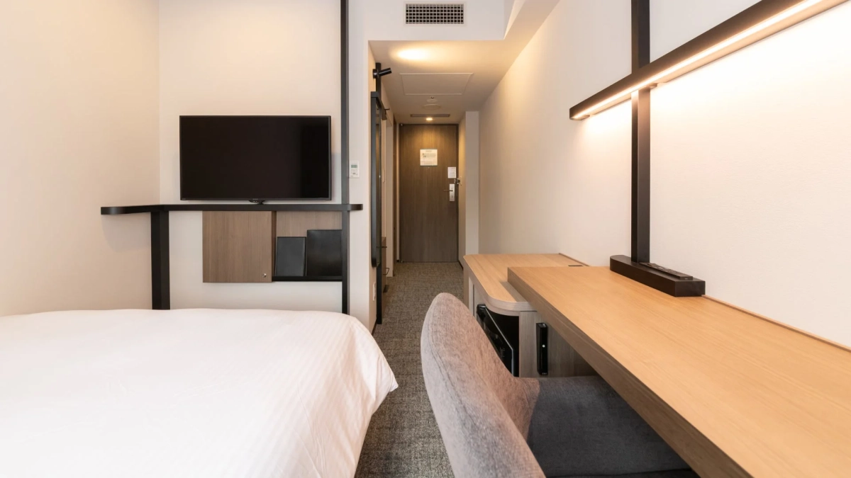 白い壁と木目調の家具で統一されたホテルの一室