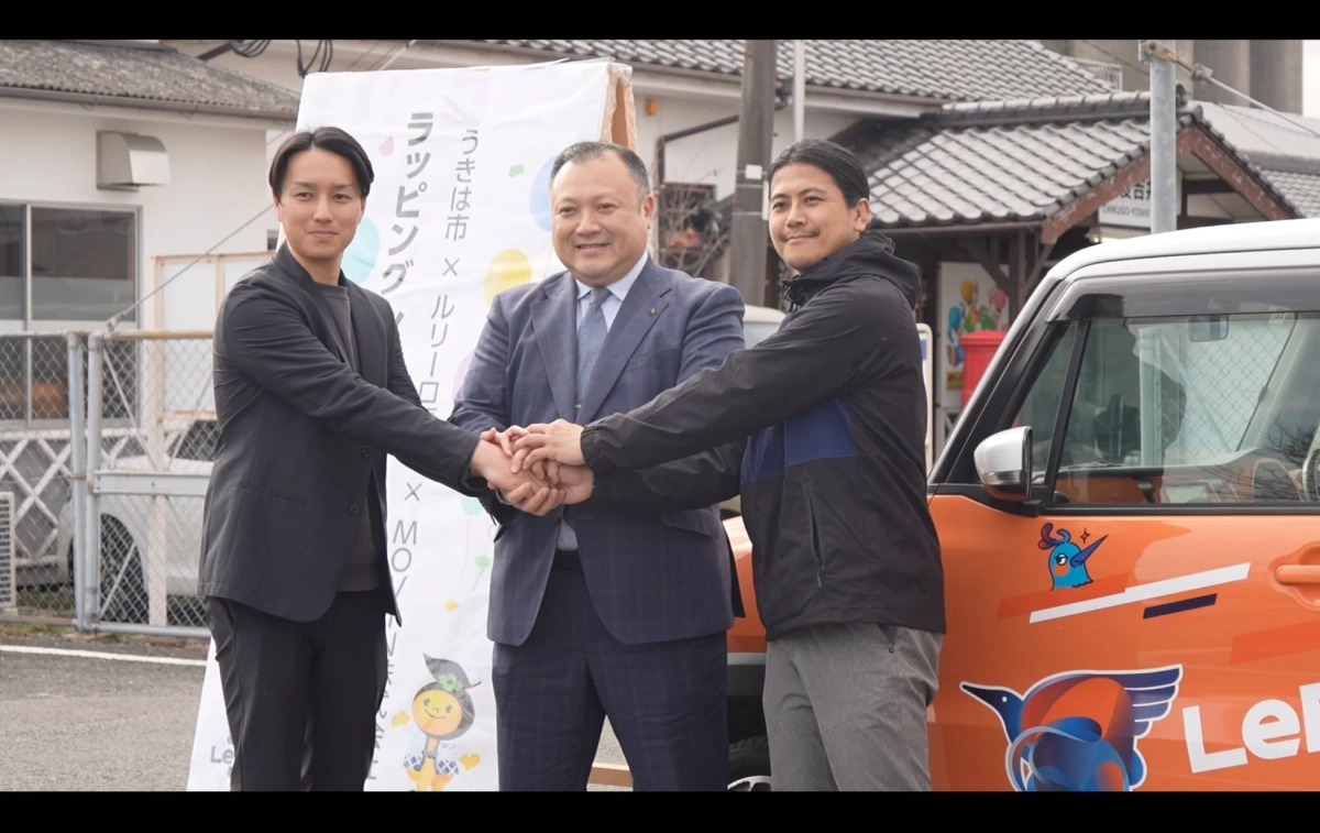 出発式で握手を交わす関係者