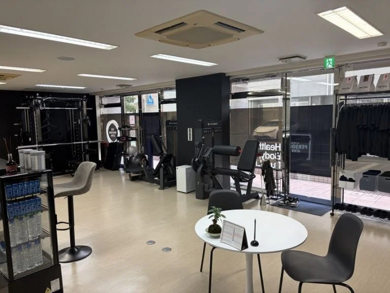 様々なトレーニングマシンが設置された、清潔感のあるモダンなフィットネスジムまたはパーソナルトレーニングスタジオ