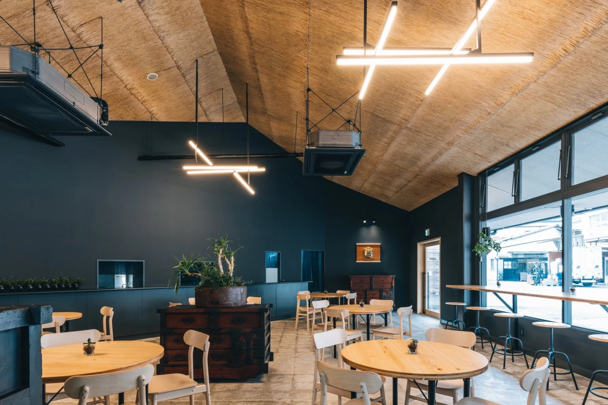 藁葺きのような天井と直線的な照明が特徴的な、モダンで落ち着いた雰囲気のカフェの内装