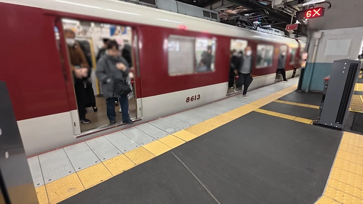 鶴橋駅のホームに停車する赤い電車とホームドア