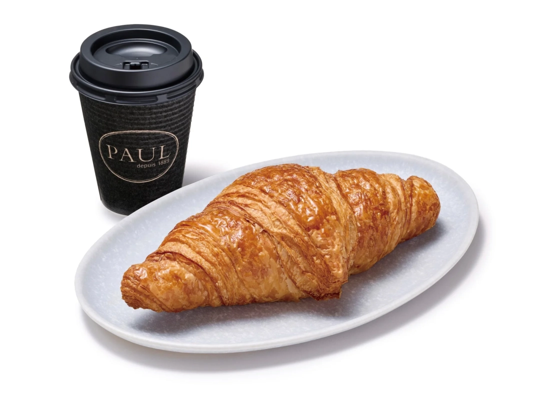 焼きたてのクロワッサンと、PAULのロゴが入ったテイクアウトカップのコーヒー