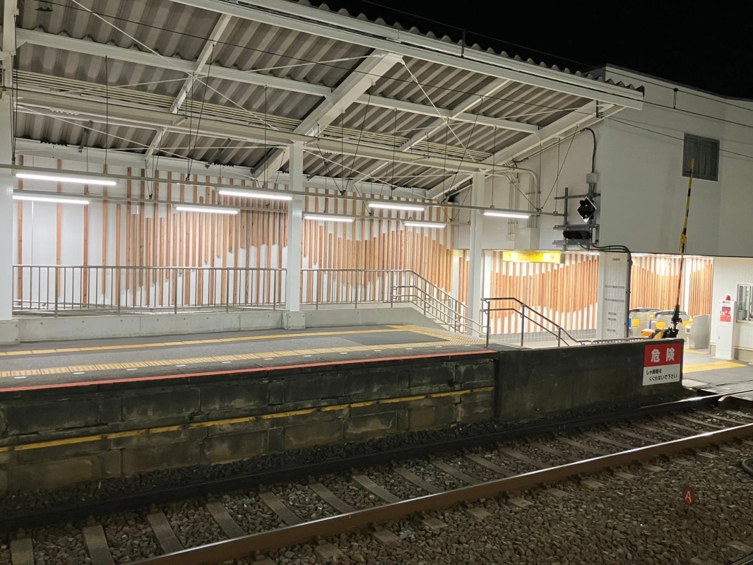 夜の駅ホームと線路、危険標識