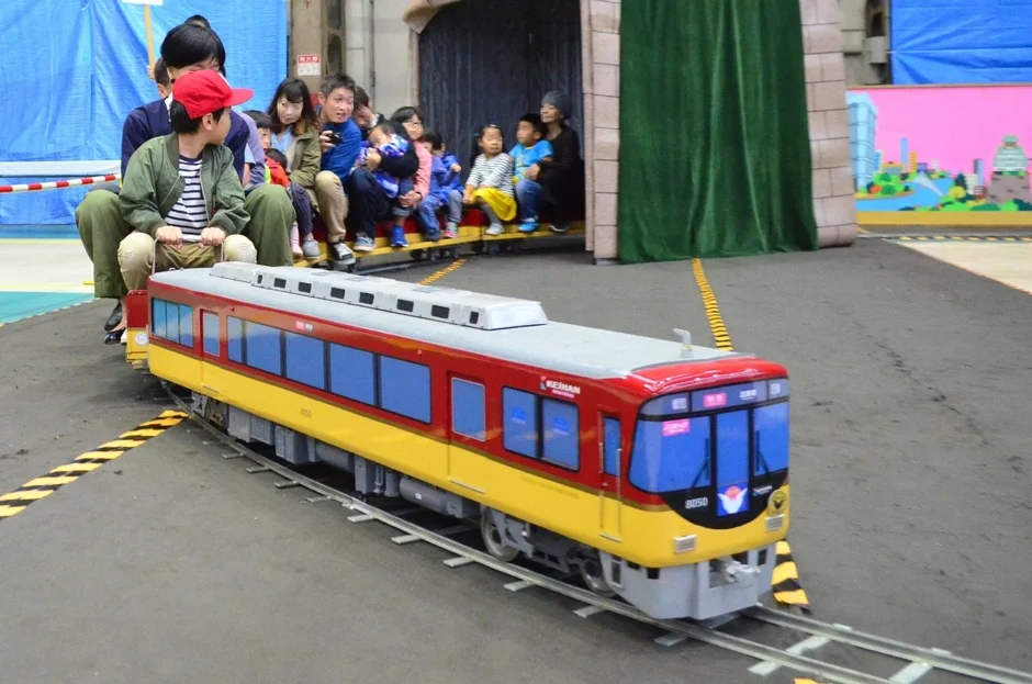 ミニチュア鉄道に乗車する家族連れ