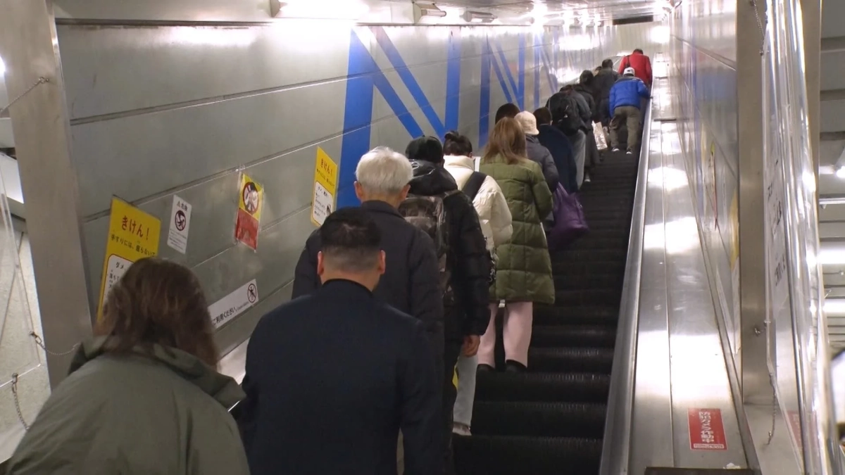 住之江公園駅のエスカレーターに乗る人々