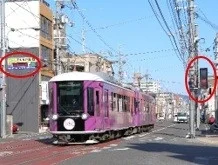紫色の路面電車、街並み、電柱、信号機、カラオケ看板