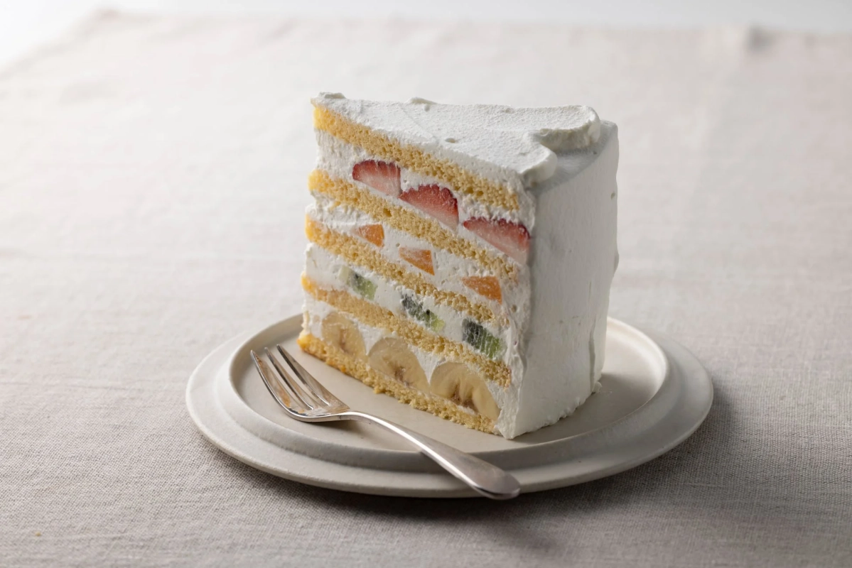 イチゴ、オレンジ、キウイ、バナナなどの様々なフルーツが挟まれたフルーツケーキ