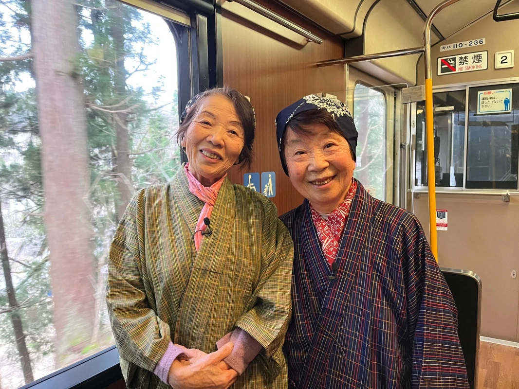列車内で笑顔を見せる2人の高齢の日本人女性