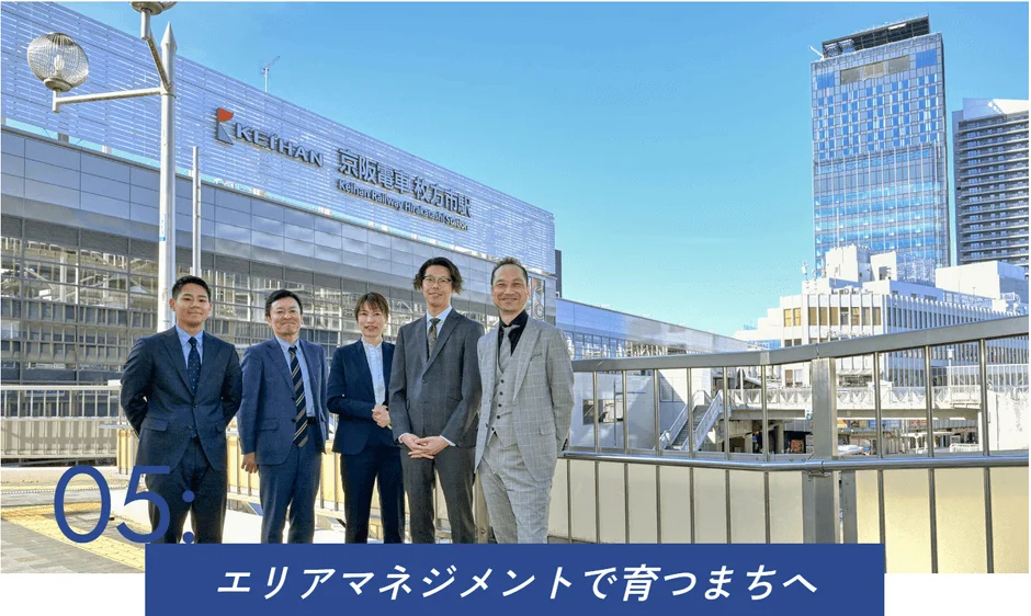 枚方市駅前で笑顔で立つビジネスパーソン