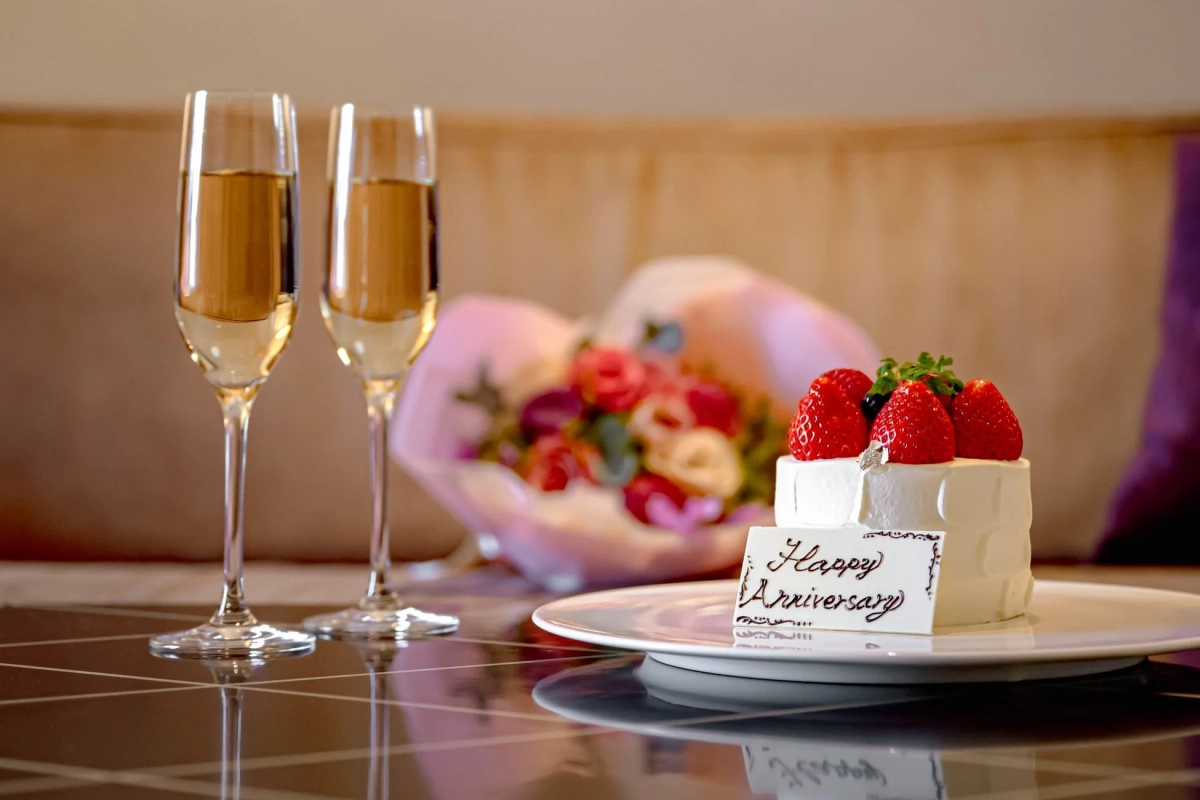 記念日を祝うシャンパンとケーキ、花束