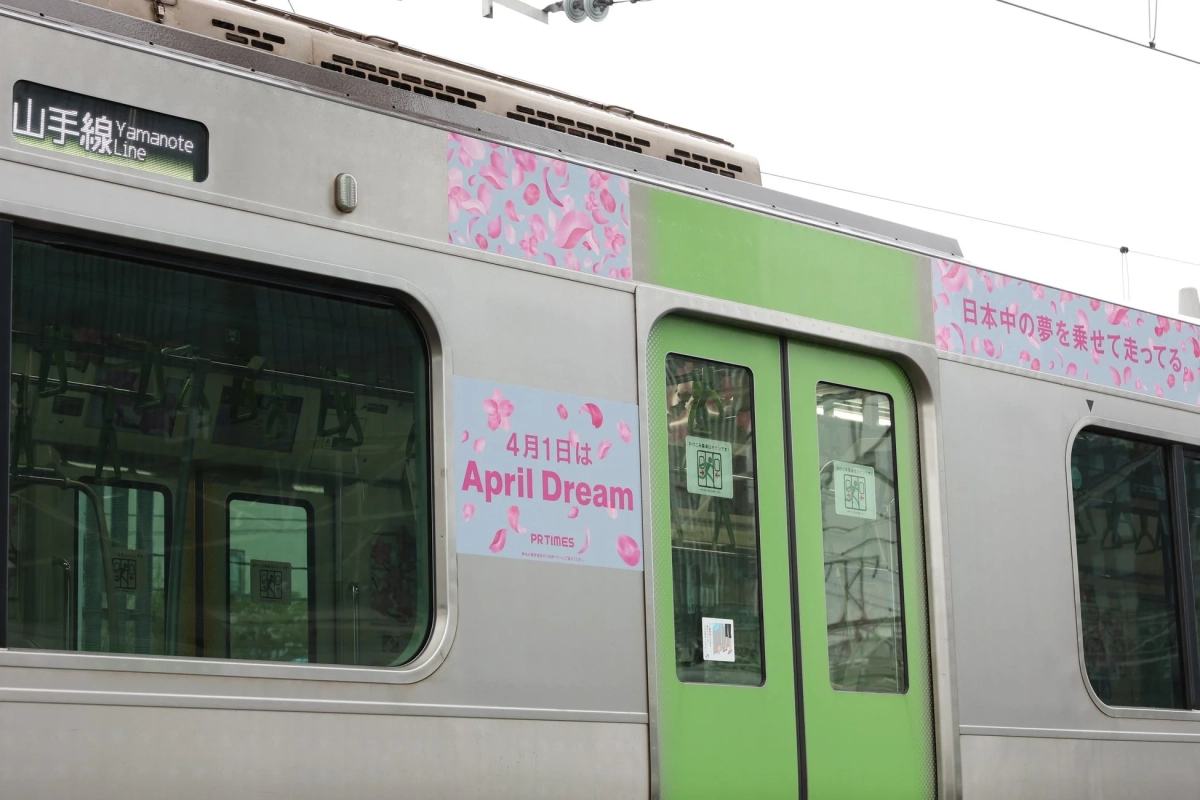 山手線の車両に桜の花びらが舞うラッピングが施され、「4月1日はApril Dream」というPR TIMESの広告が掲示されている。春らしい特別なデザインの電車。