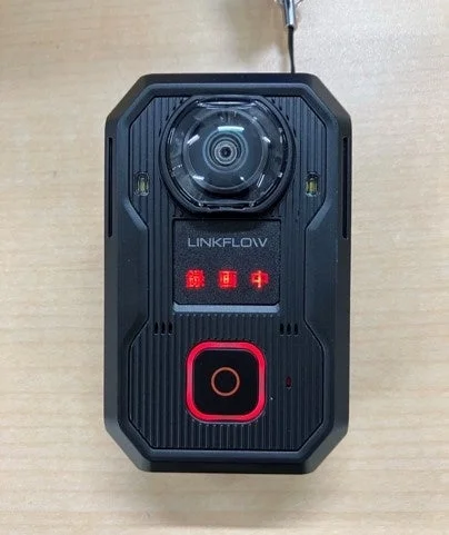 黒色のLINKFLOW製ボディカメラが写っています。中央に大きなレンズ、下部に赤い縁のボタンと複数の赤いインジケーターが点灯しており、堅牢なデザインが特徴です。