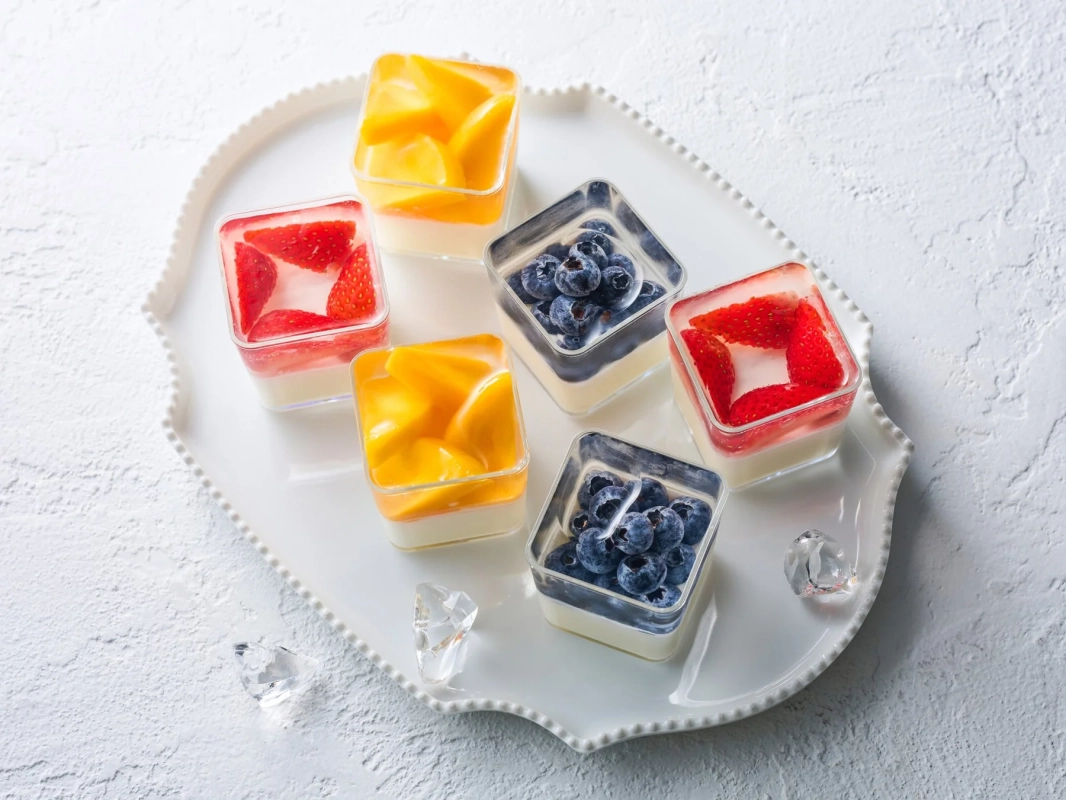 フルーツデザート,スイーツ,苺,マンゴー,ブルーベリー,パンナコッタ,ゼリー,デザートカップ,白いお皿,カラフル,フレッシュ,冷たいデザート,夏,盛り合わせ