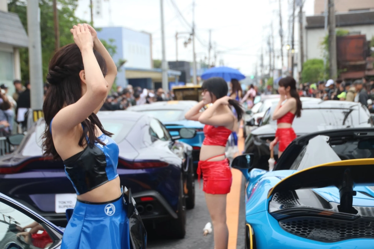 イベントでスポーツカーの横に立つレースクイーン