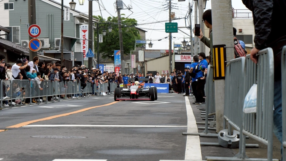 街中を走行するフォーミュラカーと観客