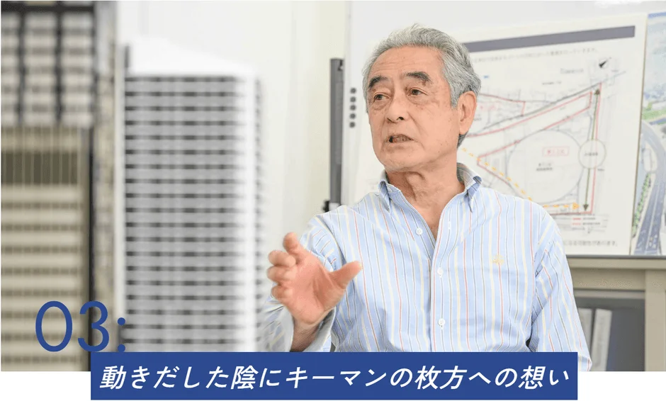 オフィスで地図を前に話すシニア男性