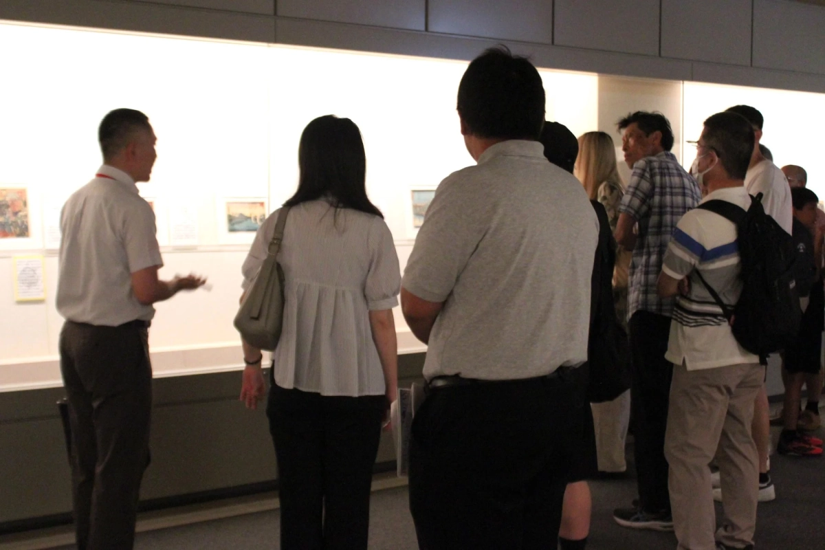 博物館のような施設で、複数の人々が展示物を鑑賞している様子