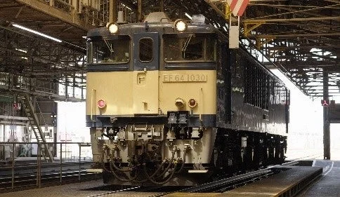 鉄道車両基地の屋内に停車しているEF64形電気機関車(EF64 1030)を正面から捉えた写真