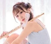 淡い光の中でフルートを抱える若い女性のポートレート