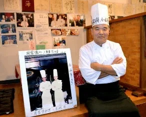 笑顔で腕組みをする日本の寿司職人