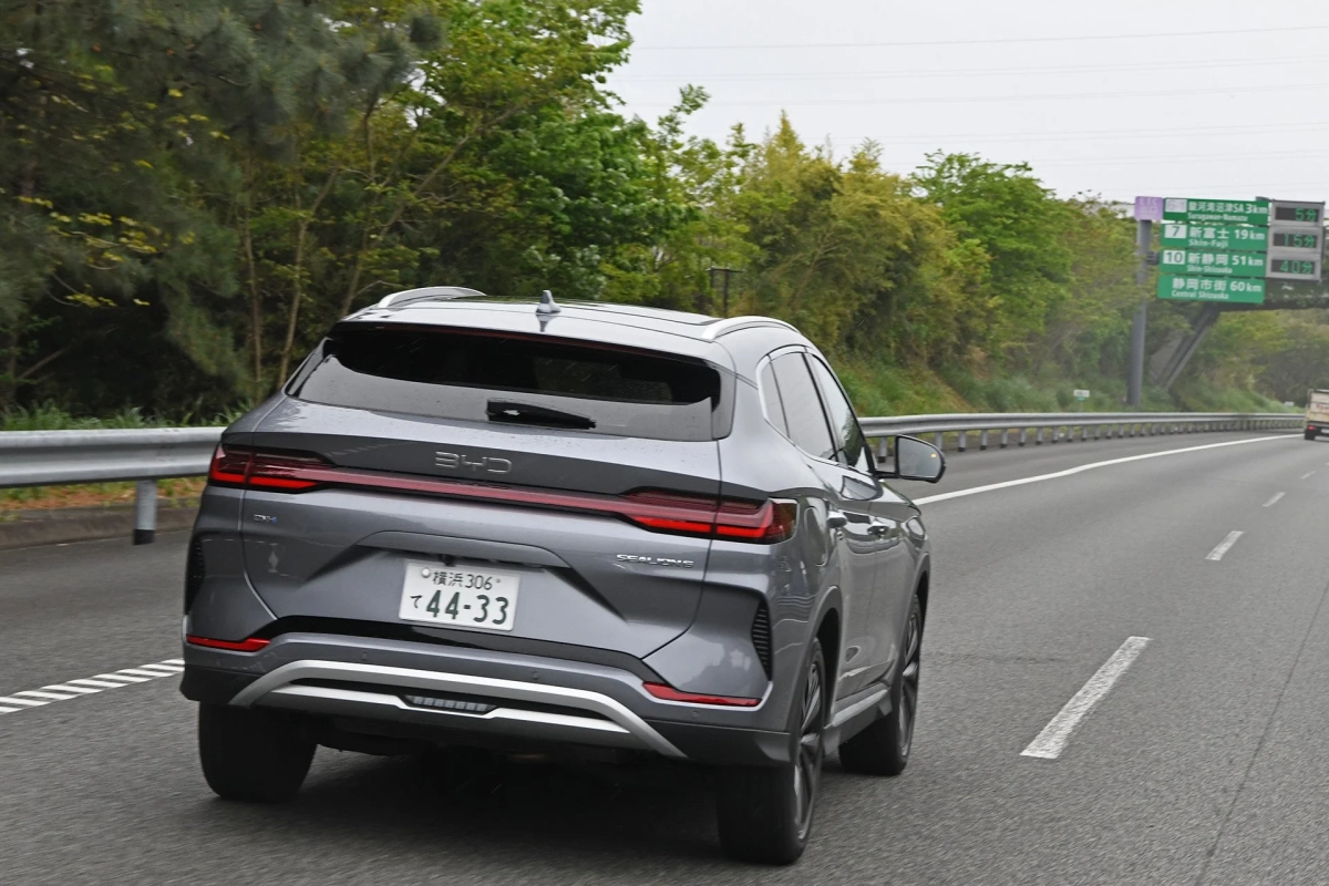 グレーのBYD製SUVが日本の高速道路を走行している後方からの写真