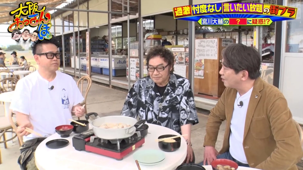 屋外の飲食店で鍋料理を囲む3人