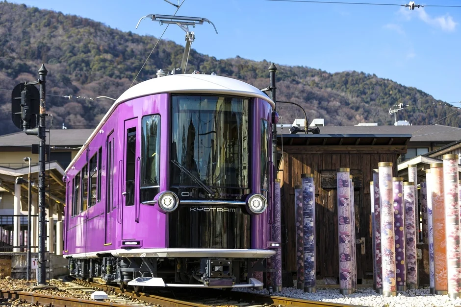 紫色の路面電車KYOTRAMが駅に停車中