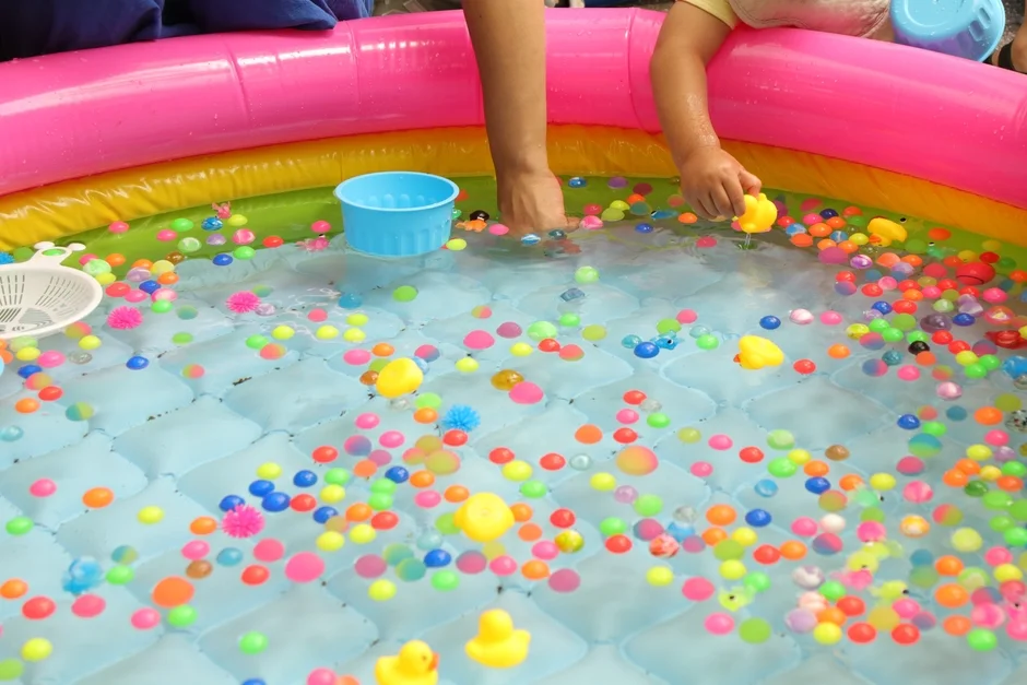 スーパーボールやアヒルが浮かぶビニールプールでの水遊び