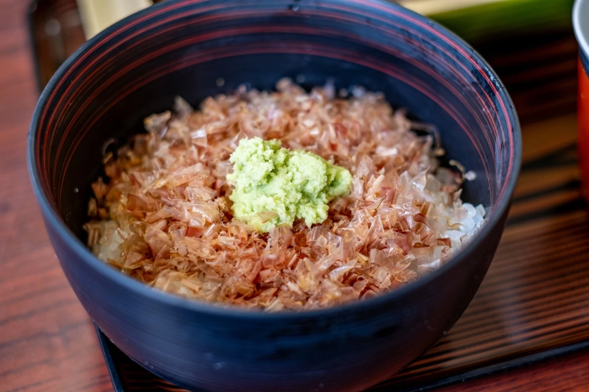 鰹節がたっぷり乗ったご飯にワサビが添えられたどんぶり