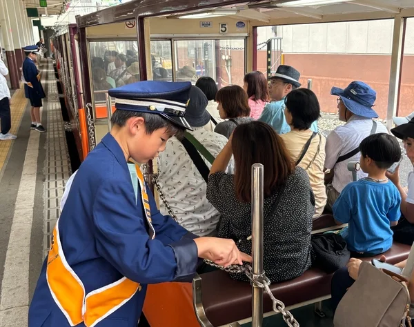 安全チェーンを操作するこども駅長