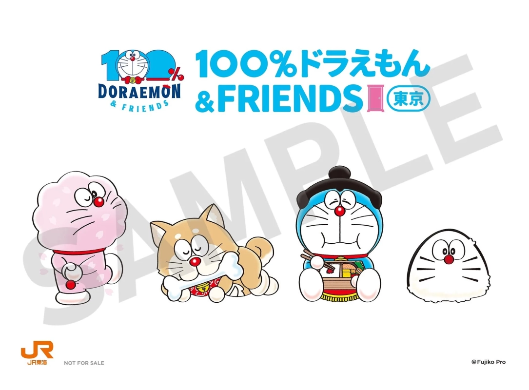 「100%ドラえもん & FRIENDS 東京」と題されたJR東海とのコラボレーションイベントのイラストです。桜の着物を着たドラミ、柴犬になったドラえもん、力士姿のドラえもん、おにぎり姿のキャラクターが描かれています。