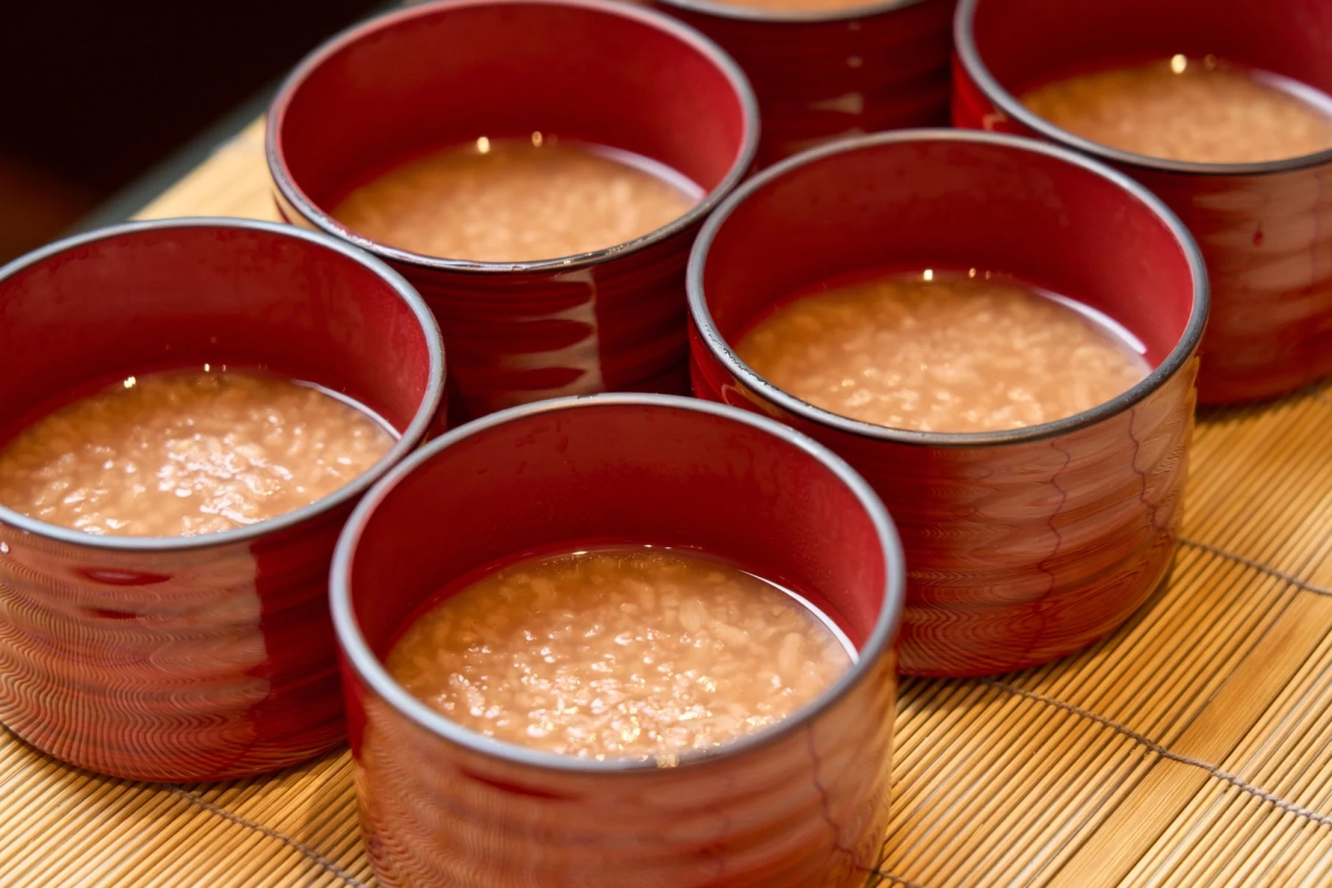 複数の赤い漆器に盛られた温かい甘酒のような飲み物