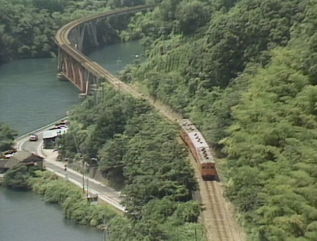 川沿いを走行する列車と鉄道橋