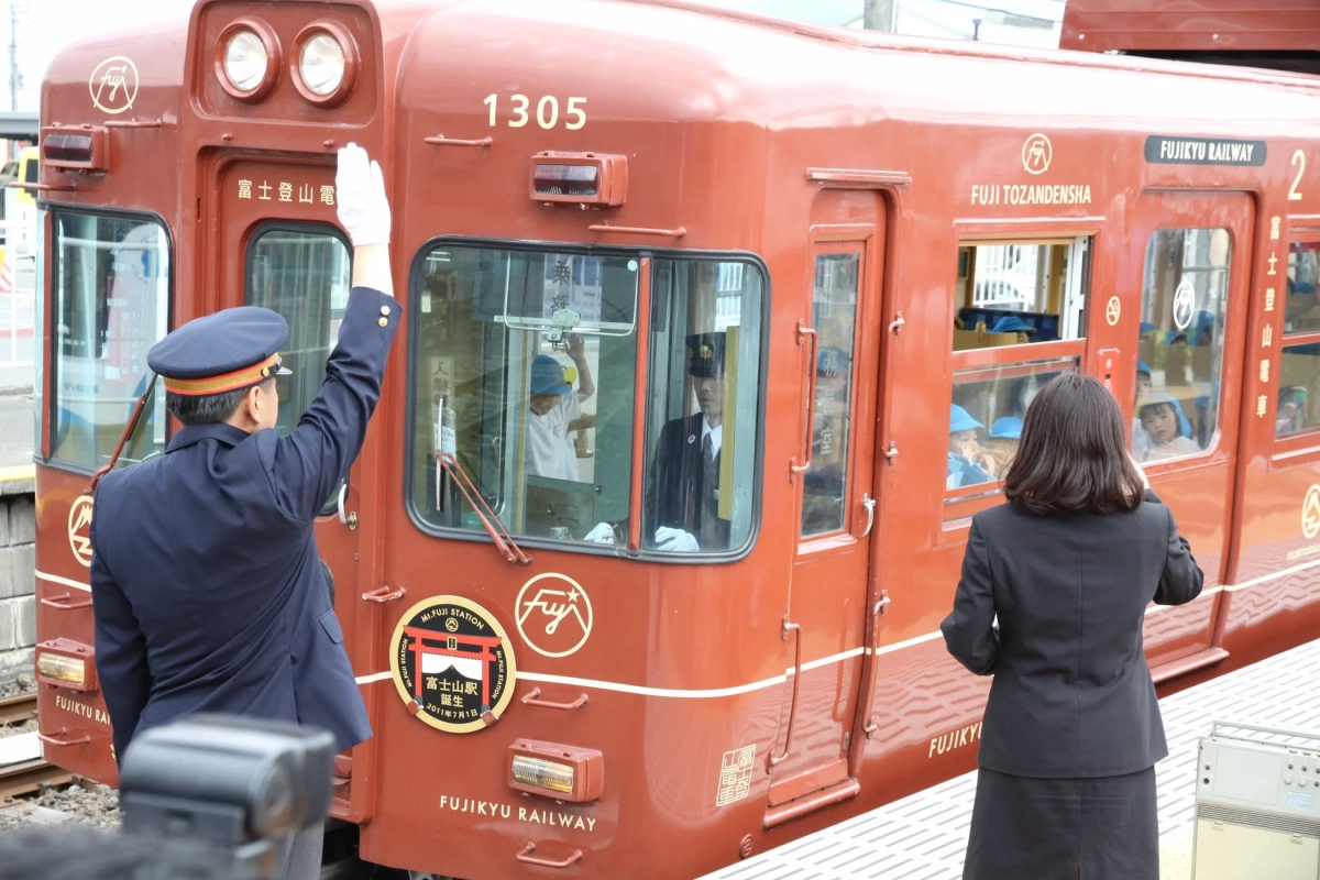 駅員と子供が電車を見送る