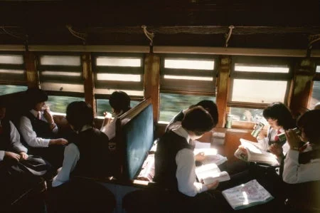 電車内で読書する学生たち