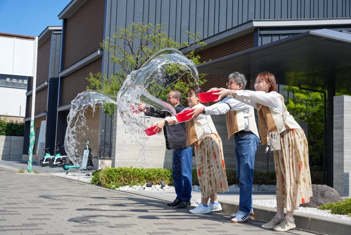 数人の人々が赤いボウルを使って勢いよく水をまいている