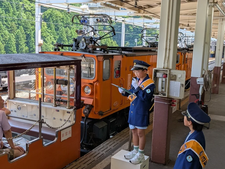 機関車の隣でアナウンスするこども駅長