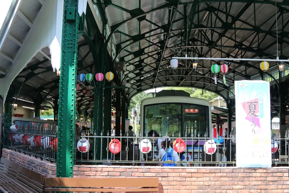 夏祭りの装飾が施された駅のホームに停車中の電車