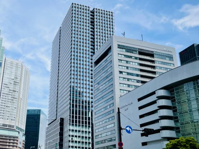 青空の下、複数の高層ビルが立ち並ぶ都市の景観です。現代的なデザインのオフィスビル群が印象的で、一部の建物には「TERMA PLAZA EAST」の文字が見えます。都会の活気を感じさせる一枚です。
