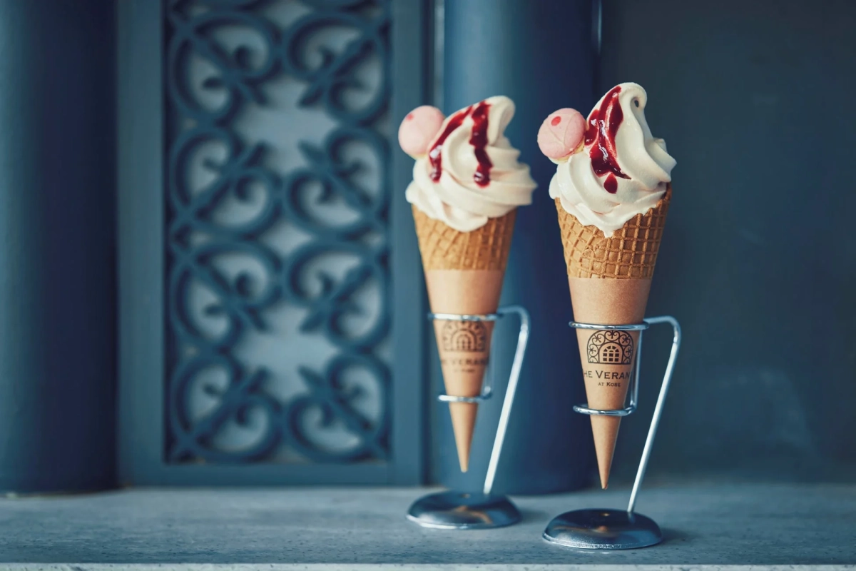 赤いソースとピンクのトッピングが添えられたソフトクリーム