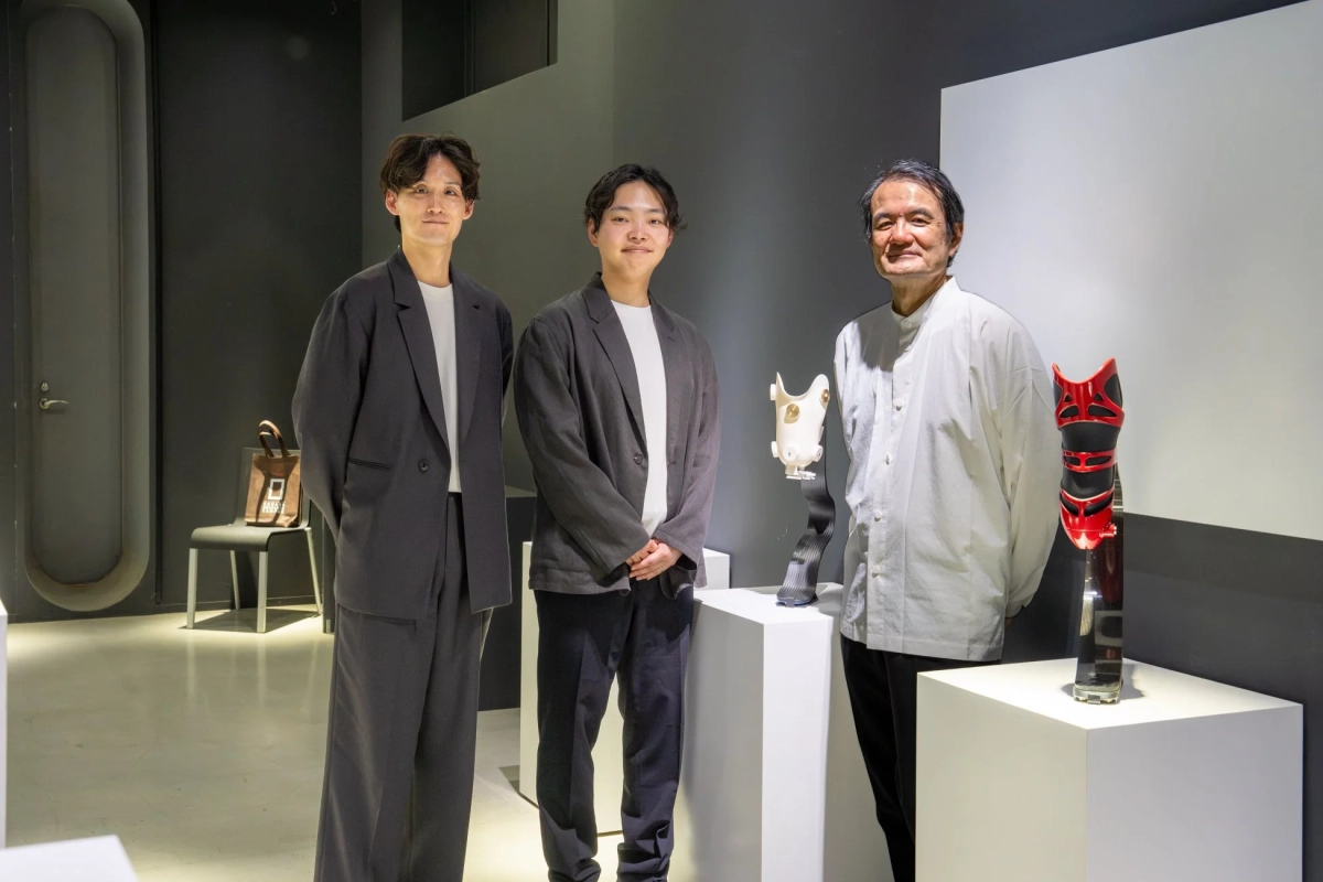 義足が展示された空間に立つ山中俊治氏を含む3人の男性